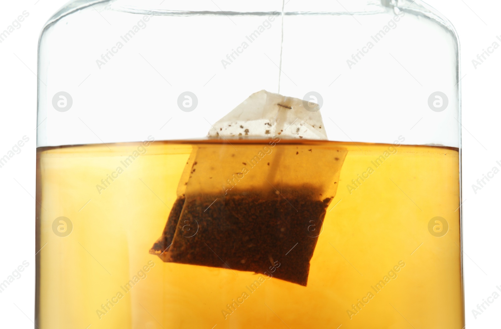 Photo of Putting tea bag into glass cup on white background, closeup