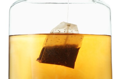 Photo of Putting tea bag into glass cup on white background, closeup