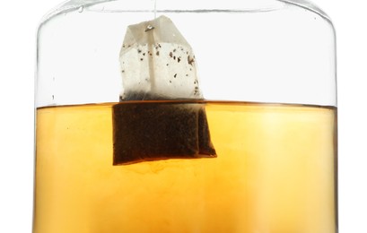 Photo of Putting tea bag into glass cup on white background, closeup