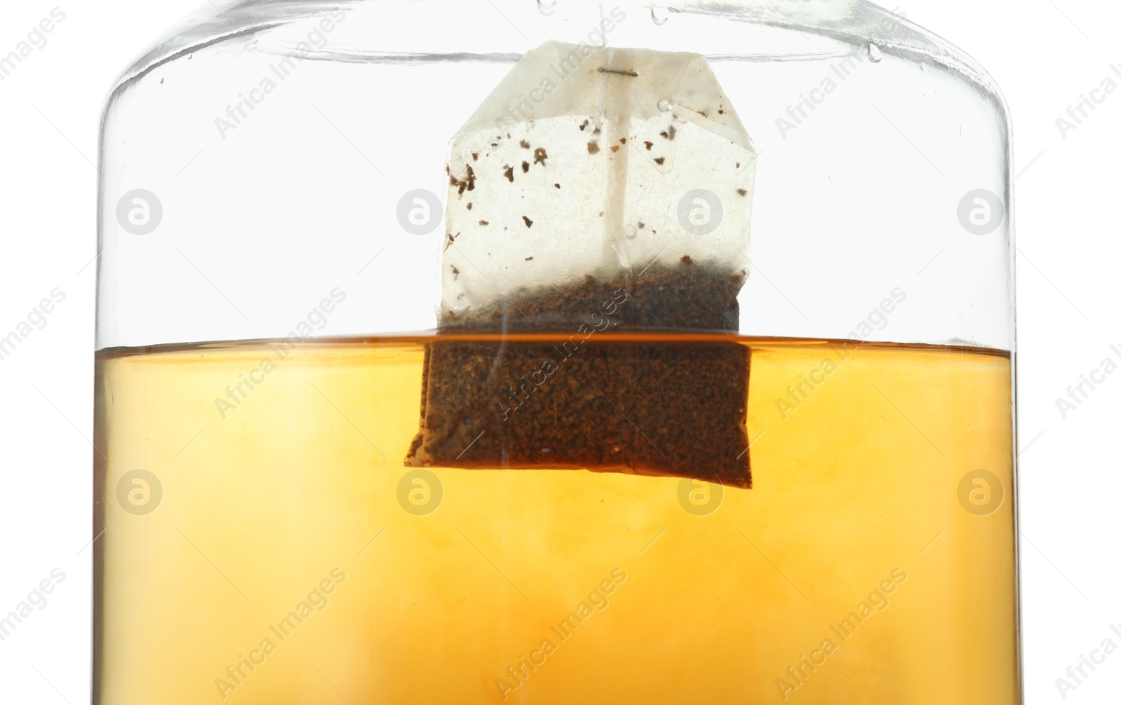 Photo of Putting tea bag into glass cup on white background, closeup