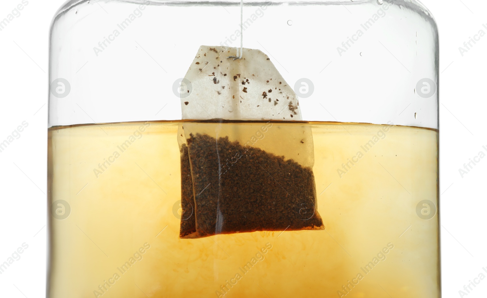 Photo of Putting tea bag into glass cup on white background, closeup