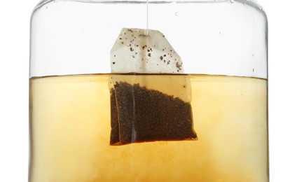 Photo of Putting tea bag into glass cup on white background, closeup