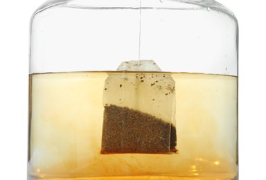 Photo of Putting tea bag into glass cup on white background, closeup