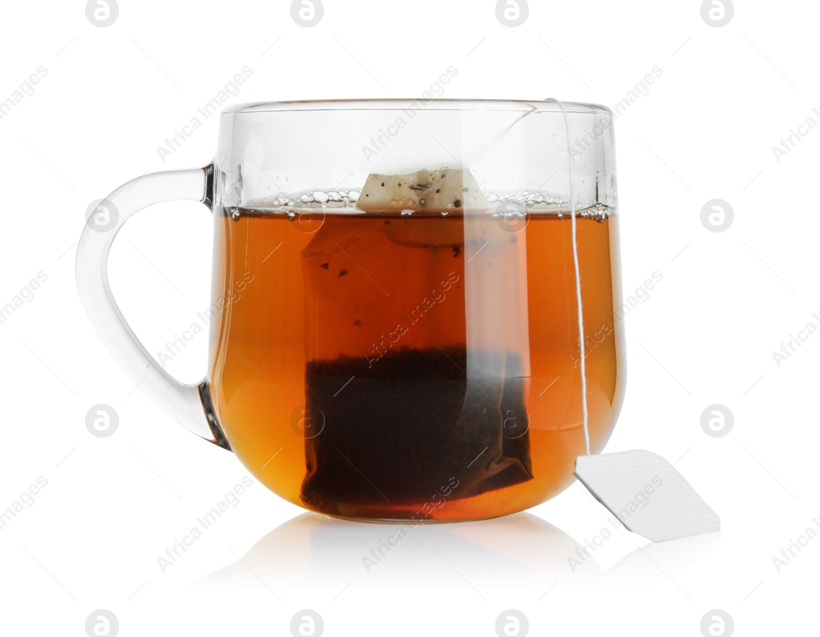 Photo of Tea bag in glass cup with hot drink isolated on white