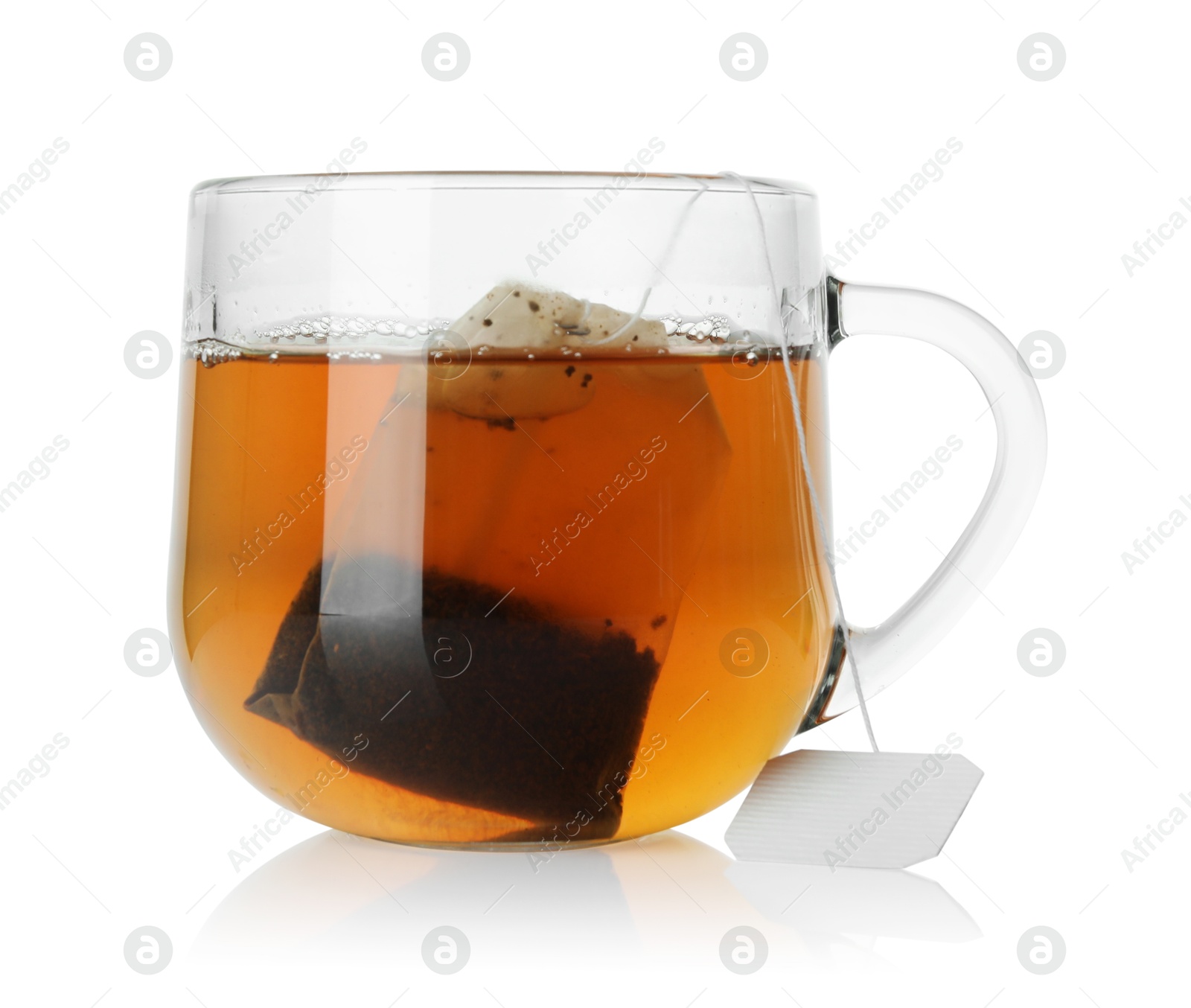 Photo of Tea bag in glass cup with hot drink isolated on white