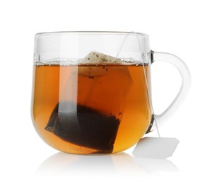 Photo of Tea bag in glass cup with hot drink isolated on white