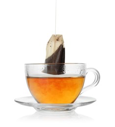 Photo of Putting tea bag into glass cup on white background