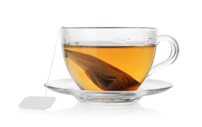 Photo of Tea bag in glass cup with hot drink isolated on white