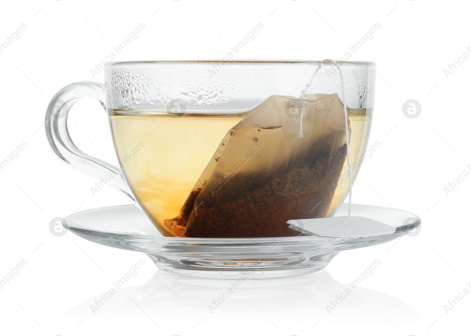 Photo of Tea bag in glass cup with hot drink isolated on white