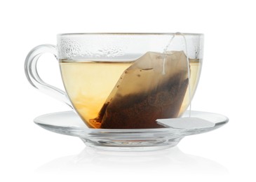 Photo of Tea bag in glass cup with hot drink isolated on white