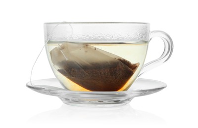 Photo of Tea bag in glass cup with hot drink isolated on white