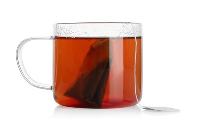 Photo of Tea bag in glass cup with hot drink isolated on white