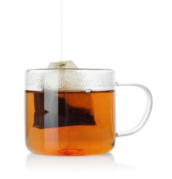 Photo of Putting tea bag into glass cup on white background