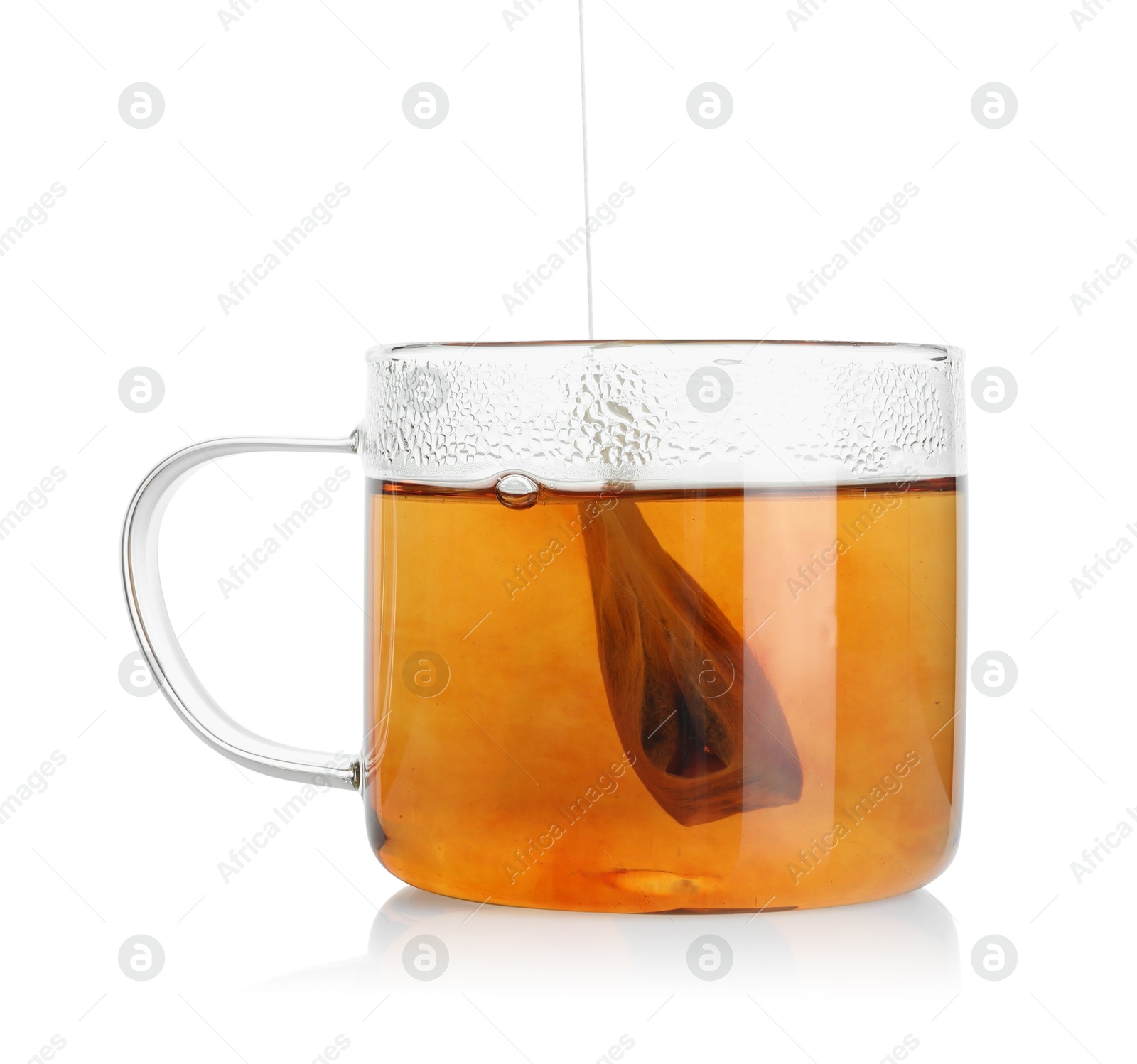 Photo of Putting tea bag into glass cup on white background