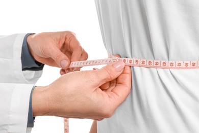 Photo of Weight loss. Nutritionist measuring patient's waist with tape on white background, closeup