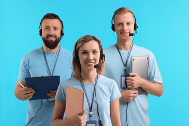 Photo of Technical support call center. Team of friendly operators on light blue background