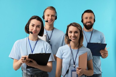 Photo of Technical support call center. Team of friendly operators on light blue background