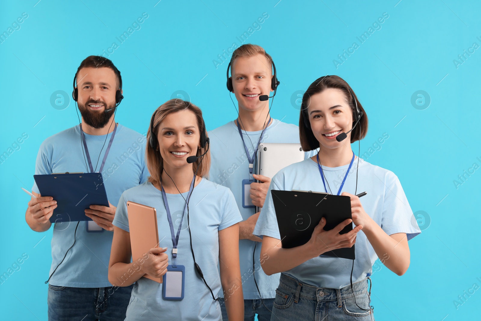 Photo of Technical support call center. Team of friendly operators on light blue background