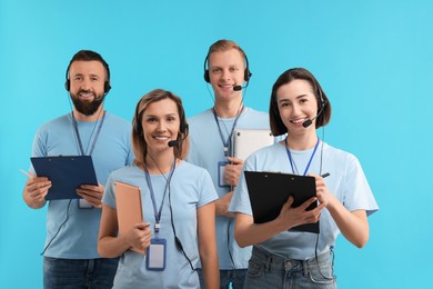 Technical support call center. Team of friendly operators on light blue background