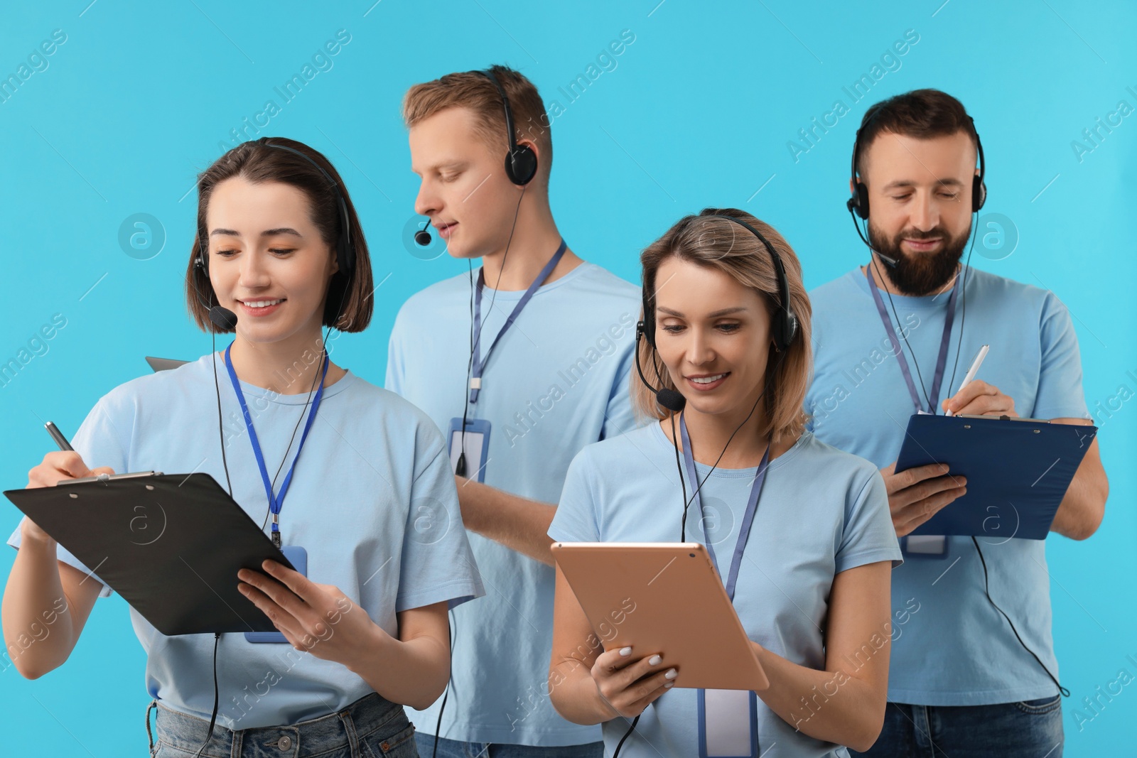 Photo of Technical support call center. Team of friendly operators working on light blue background