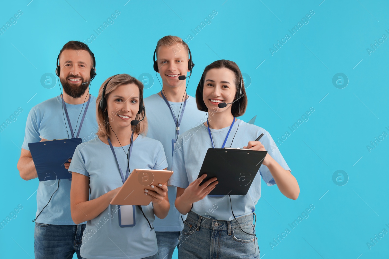 Photo of Technical support call center. Team of friendly operators on light blue background