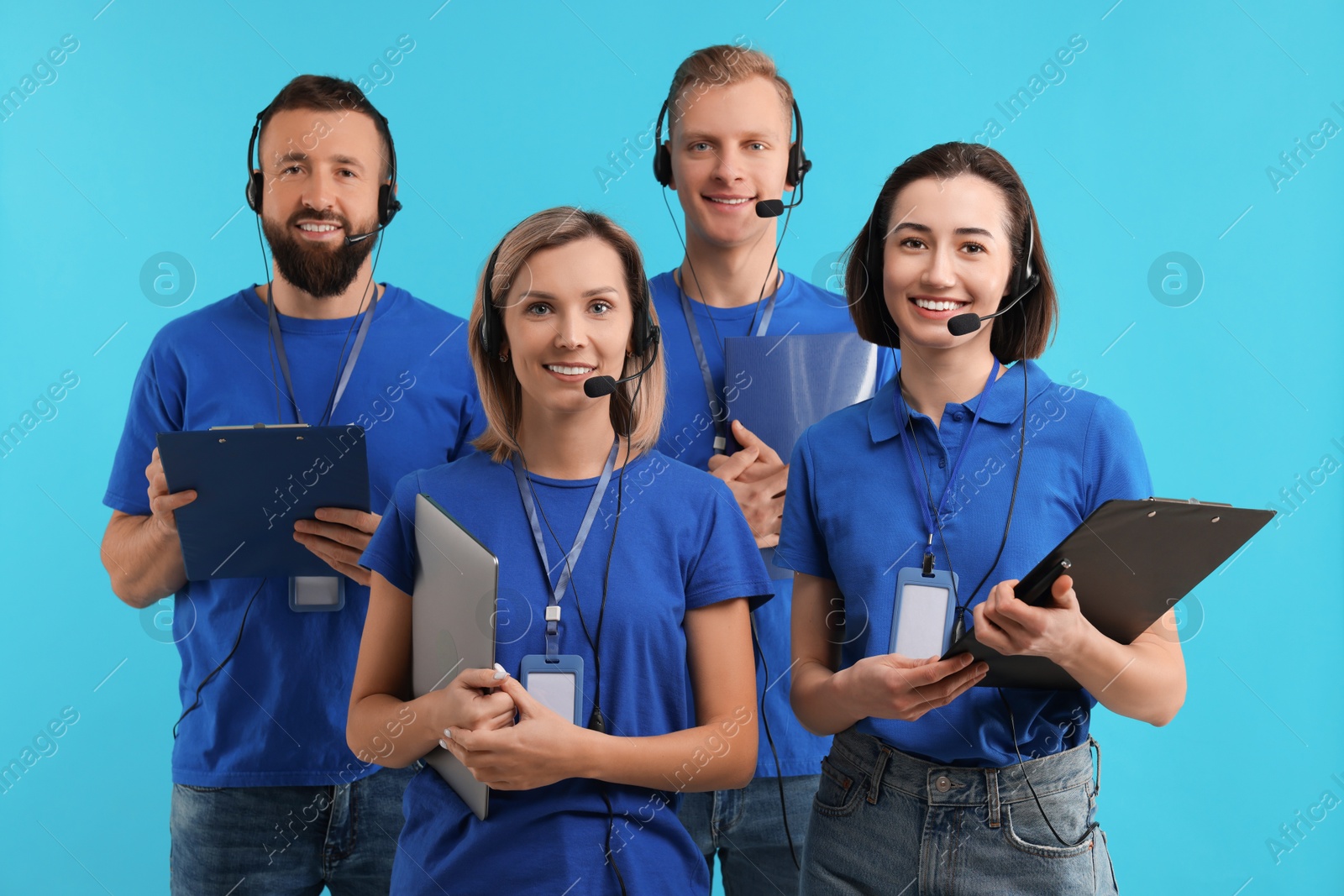 Photo of Technical support call center. Team of friendly operators on light blue background