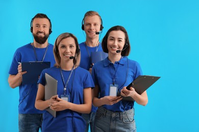 Photo of Technical support call center. Team of friendly operators on light blue background