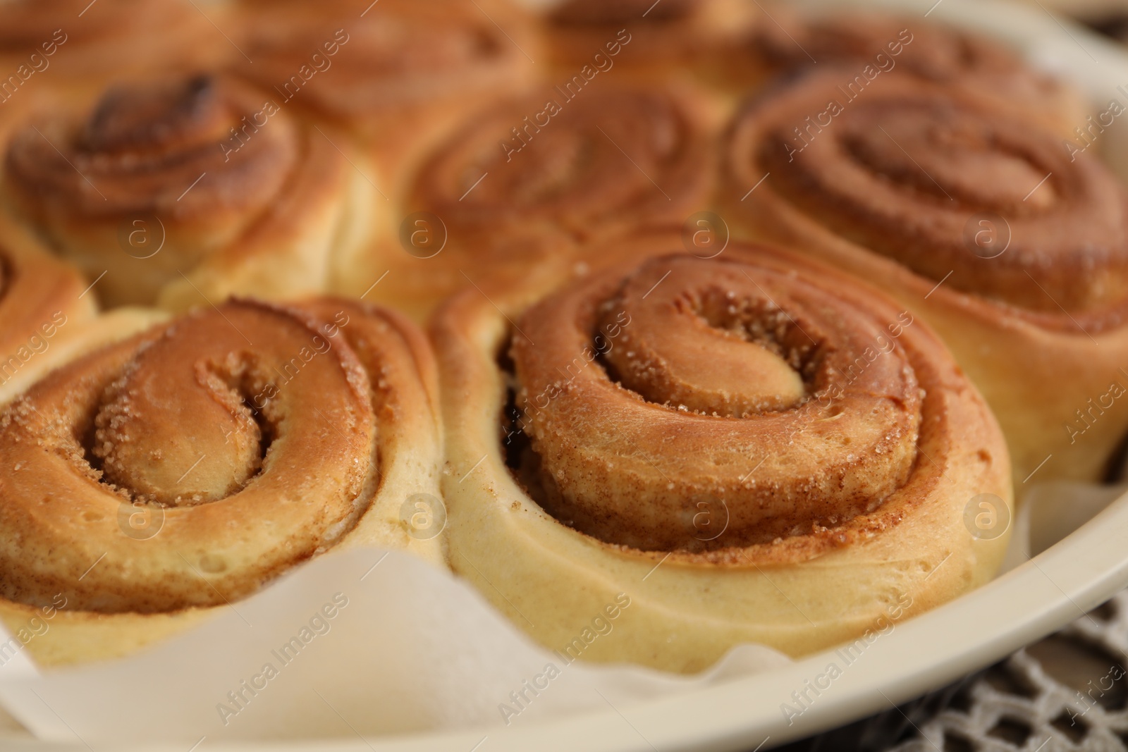 Photo of Freshly baked cinnamon rolls in baking dish, closeup