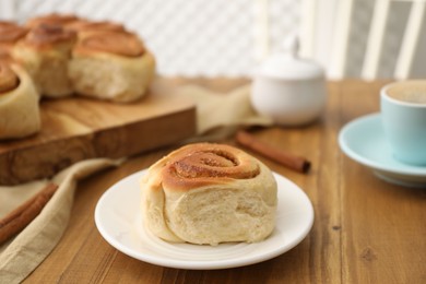 Photo of Freshly baked cinnamon roll on wooden table, closeup