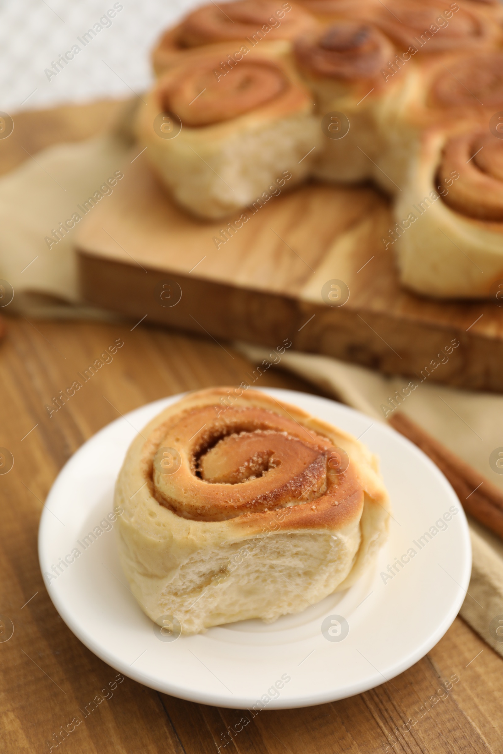 Photo of Freshly baked cinnamon roll on wooden table, closeup