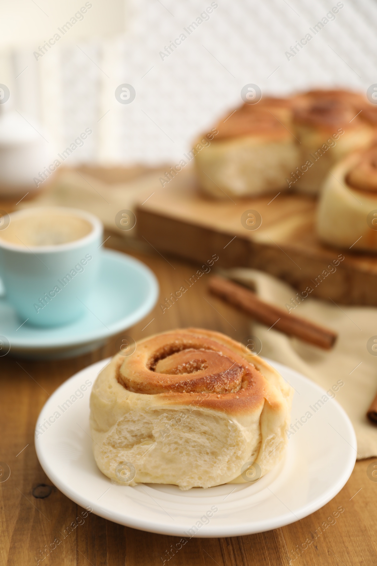 Photo of Freshly baked cinnamon roll on wooden table, closeup