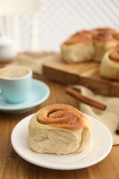 Photo of Freshly baked cinnamon roll on wooden table, closeup