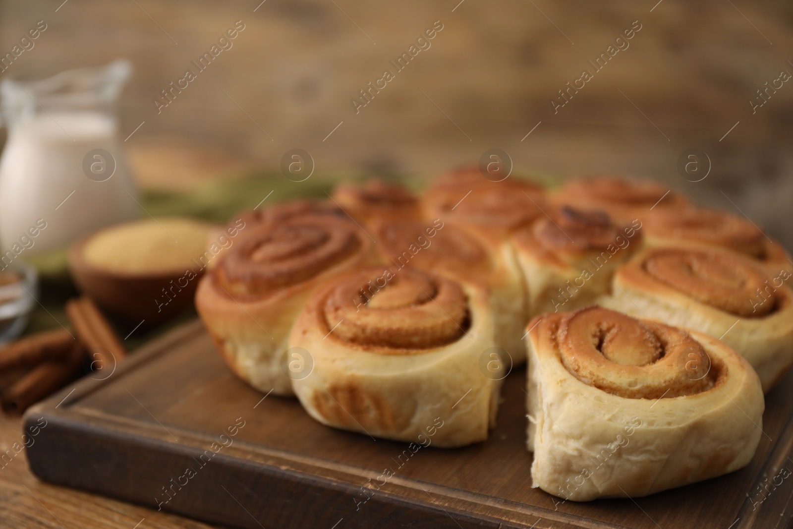 Photo of Freshly baked cinnamon rolls on wooden table, closeup