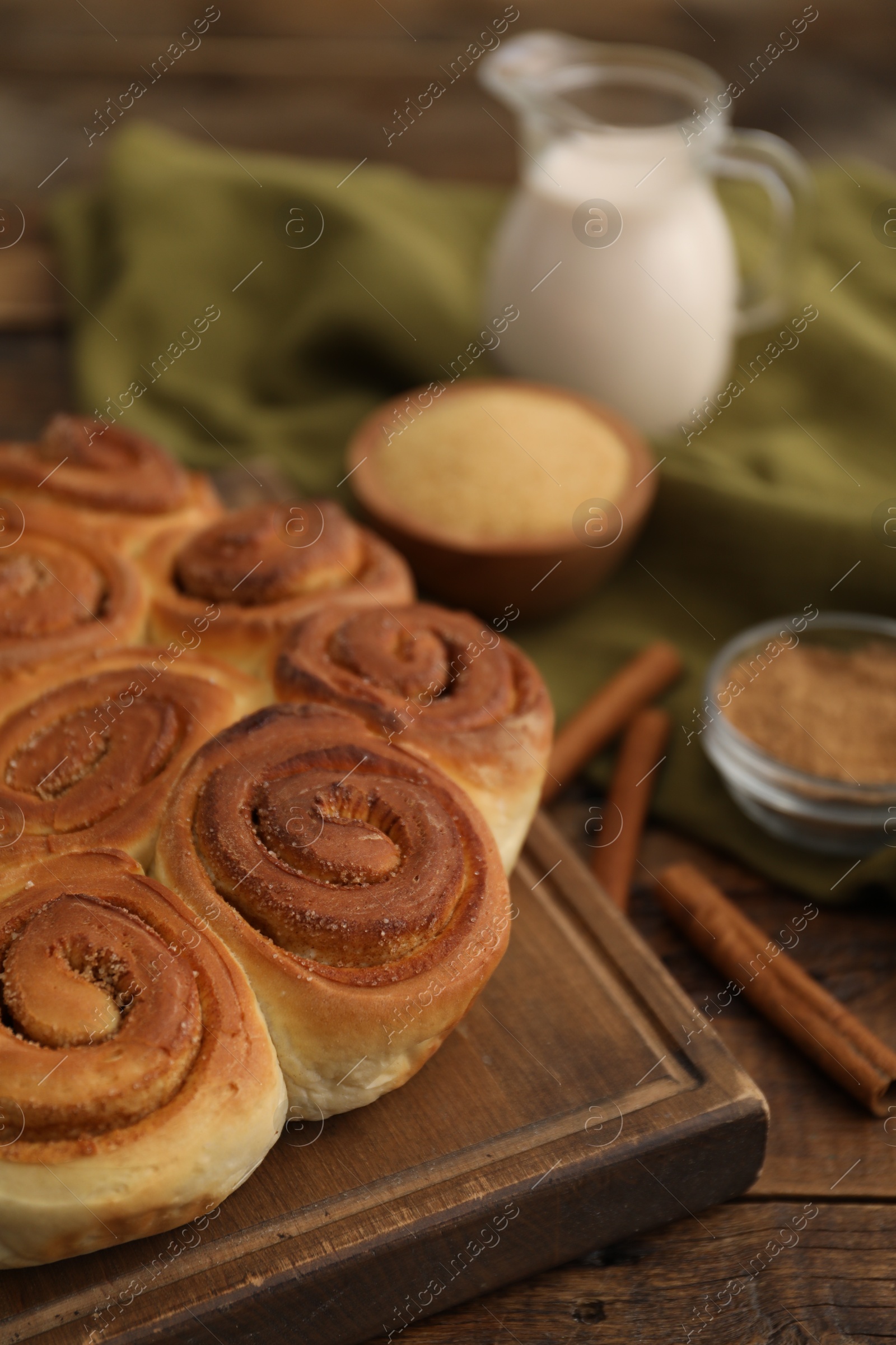 Photo of Freshly baked cinnamon rolls on wooden table, closeup