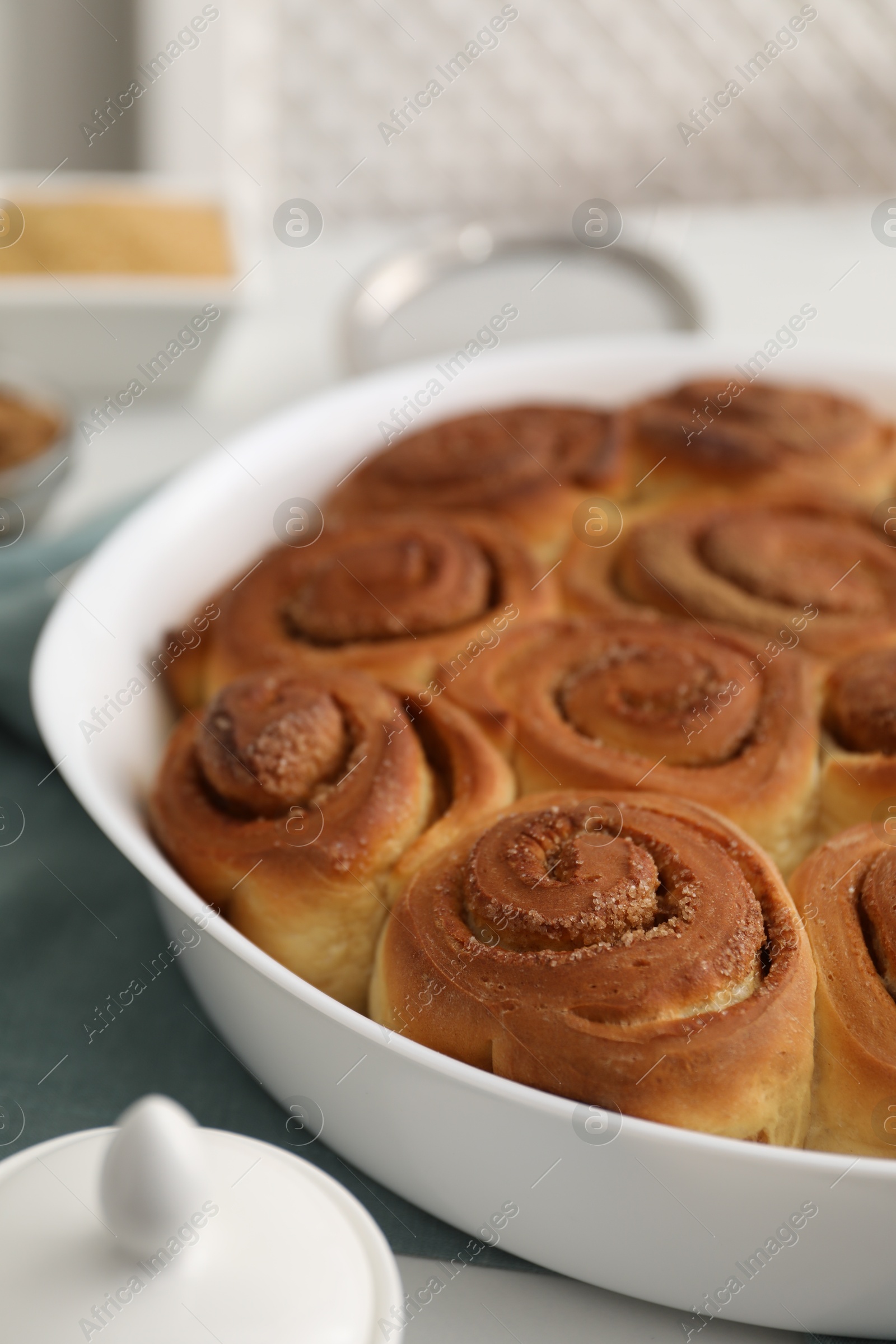 Photo of Tasty cinnamon rolls on white table, closeup