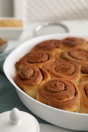 Photo of Tasty cinnamon rolls on white table, closeup