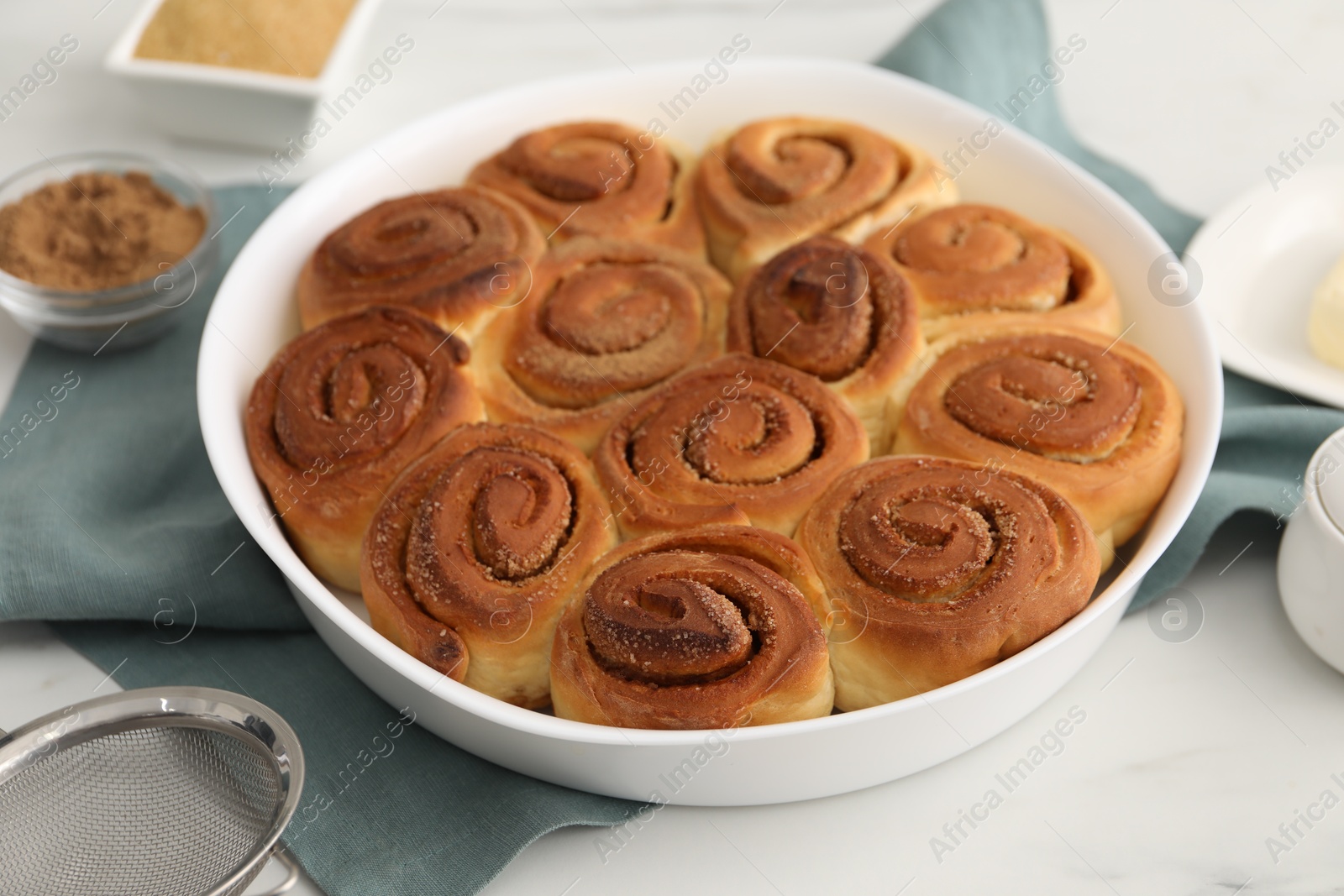 Photo of Tasty cinnamon rolls on white table, closeup