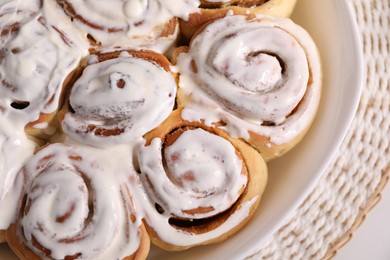 Photo of Delicious frosted cinnamon rolls on white table, top view