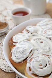 Delicious frosted cinnamon rolls on table, closeup