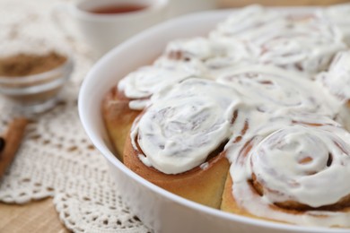 Delicious frosted cinnamon rolls on table, closeup