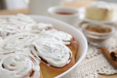 Delicious frosted cinnamon rolls on table, closeup