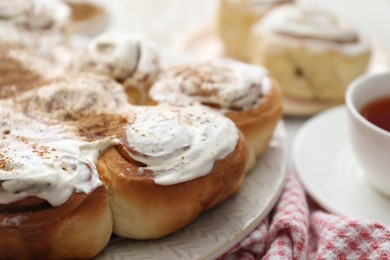 Delicious frosted cinnamon rolls on table, closeup