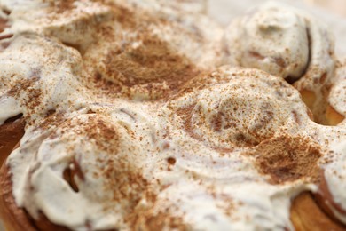 Photo of Delicious frosted cinnamon rolls as background, closeup