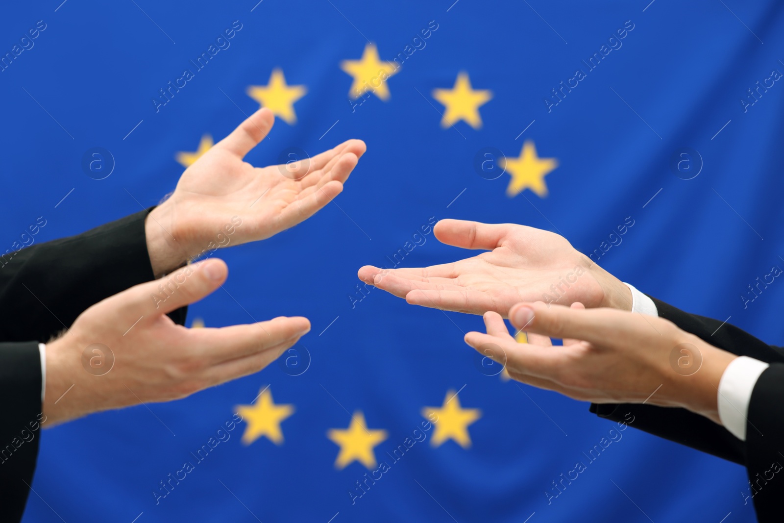 Photo of Diplomats negotiating during meeting against flag of European Union, closeup