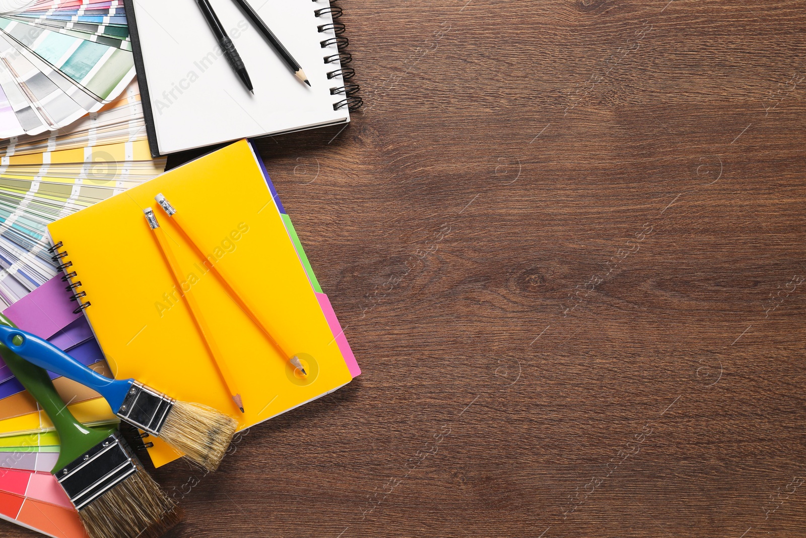 Photo of Flat lay composition with different painter's tools on wooden table, space for text. Decorating and design