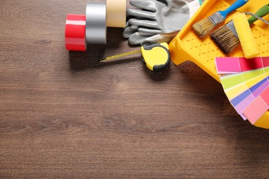 Photo of Flat lay composition with different painter's tools on wooden table, space for text. Decorating and design