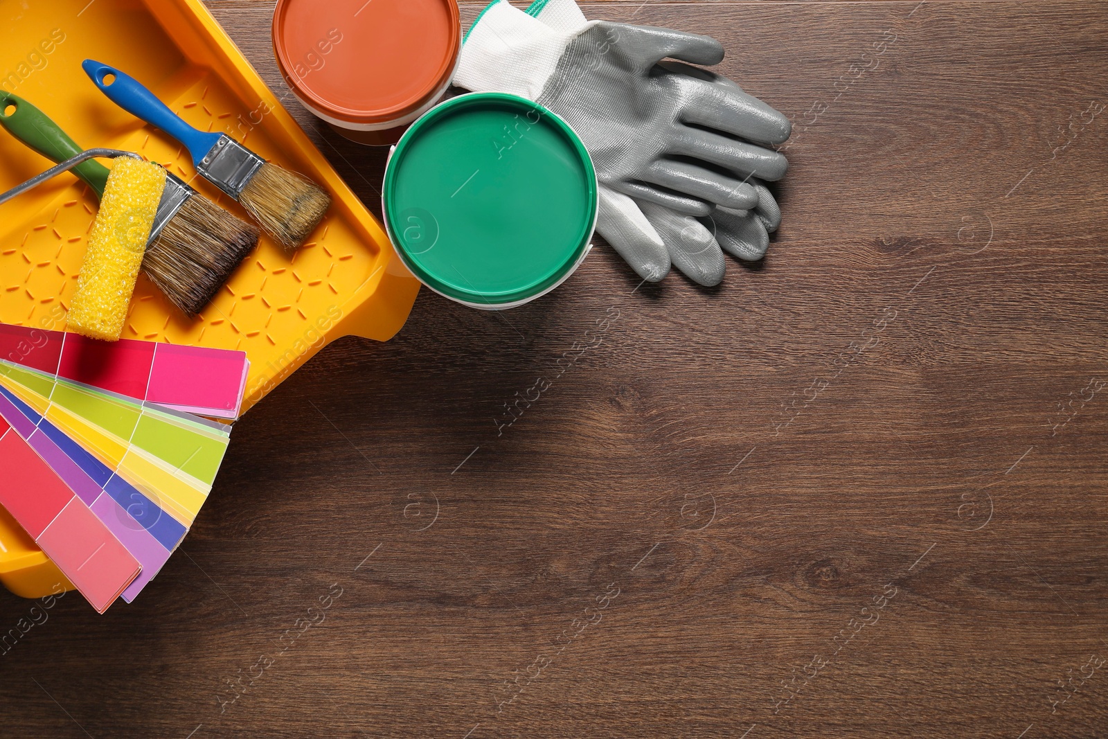 Photo of Flat lay composition with different painter's tools on wooden table, space for text. Decorating and design