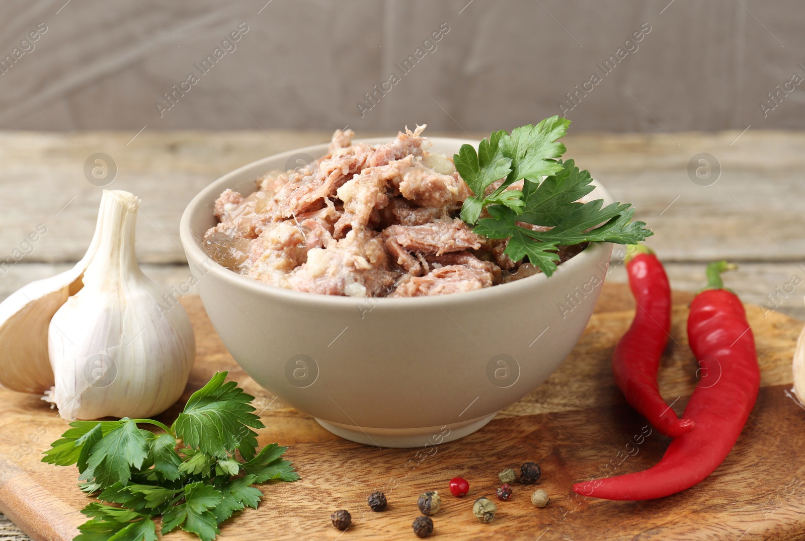 Photo of Canned meat in bowl and fresh products on table, closeup