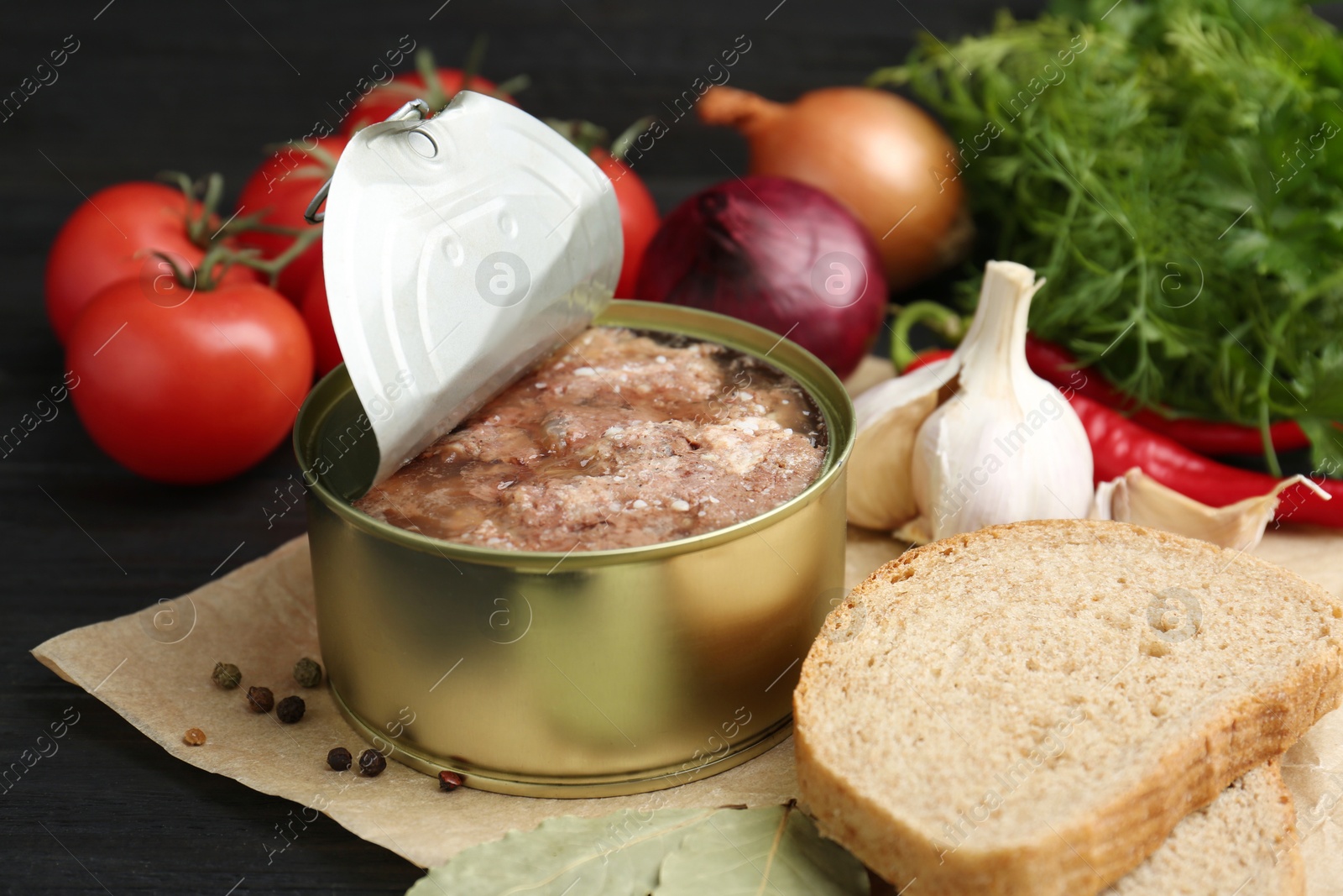 Photo of Canned meat in tin can and other products on table, closeup