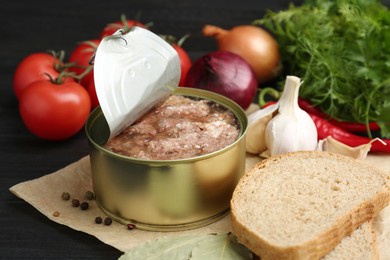 Photo of Canned meat in tin can and other products on table, closeup